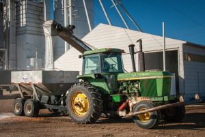 Green Tractor being loaded with Dry Fertilizer.  Berend Bros. Windthorst, and Olney, Texas